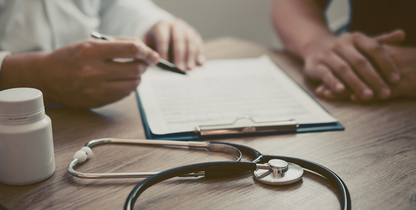 Two people at a table consulting over a contract