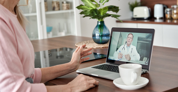 Stock image of a person having a virtual meeting from their home with a doctor