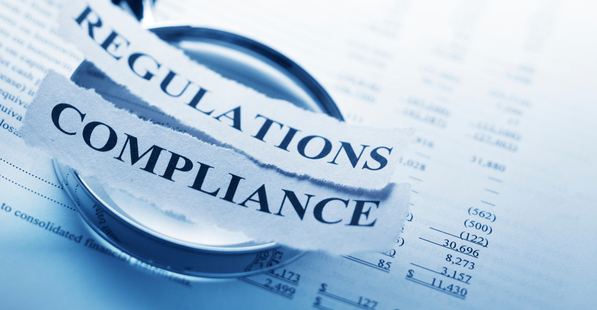 Magnifying glass over a billing statement. Paper slips with the words Regulations and Compliance are on top