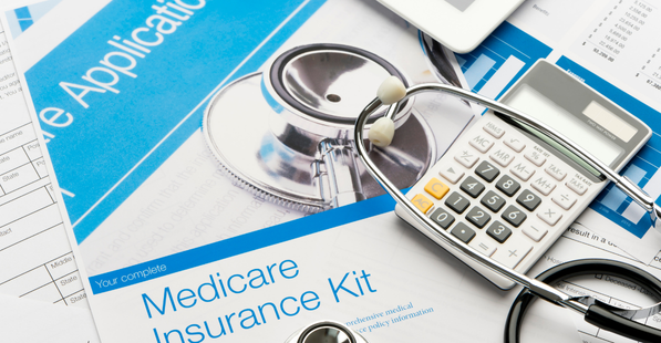 Up close image of a calculator, medical supplies, and medicare forms