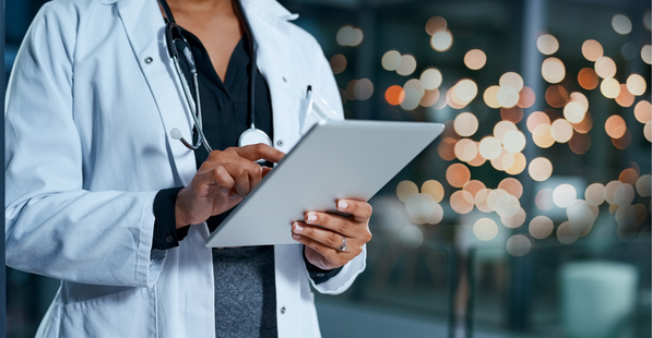 Healthcare worker in uniform holding and working on a device