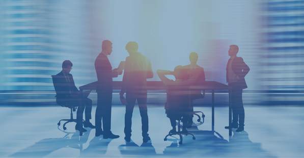 Blurred image of people standing around a conference table with a dark blue layer over top