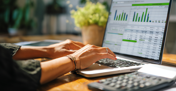 Person working at a computer with data and dashboards on the screen