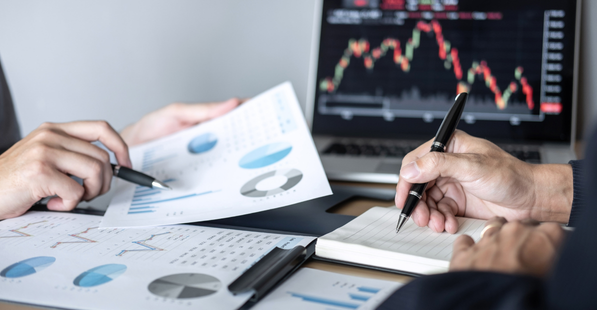 People collaborating over a sheet with graphs and charts