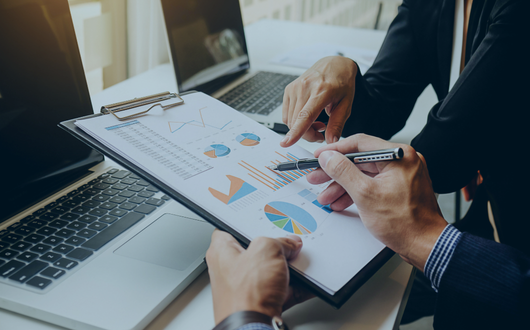 people collaborating over a clipboard with analytics information