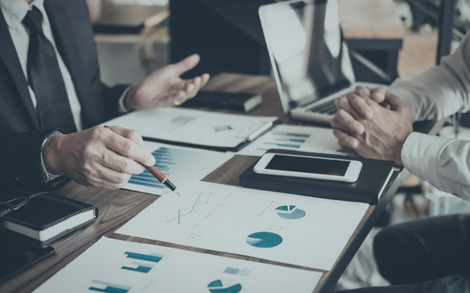 people sitting at a desk reviewing analytics