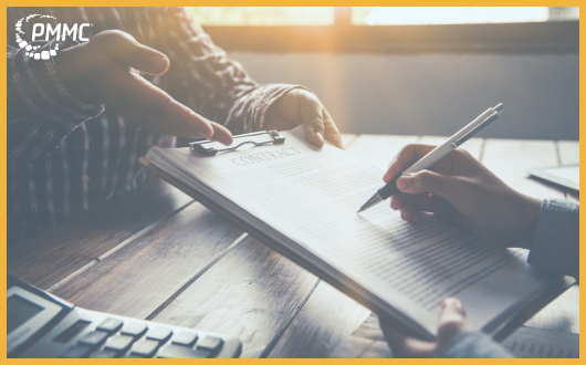 A person at a desk signing a contract document