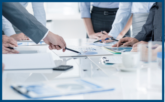 People working together at a table with papers of graphs and charts