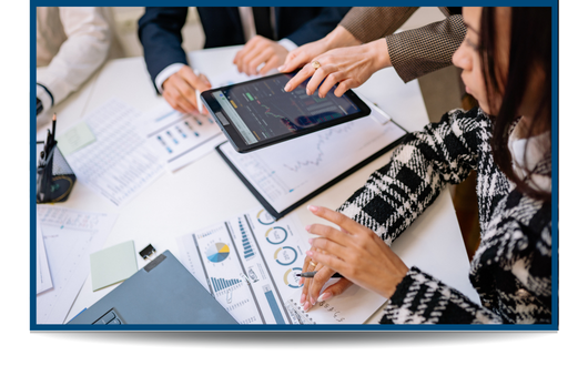 People working together at a table with papers of graphs and charts