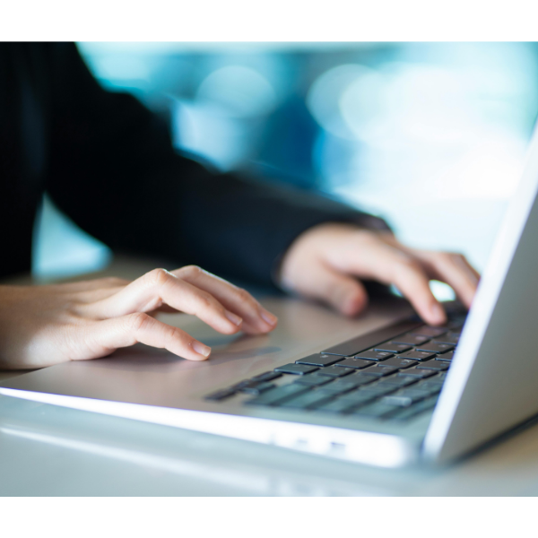 Hands typing on a laptop keyboard